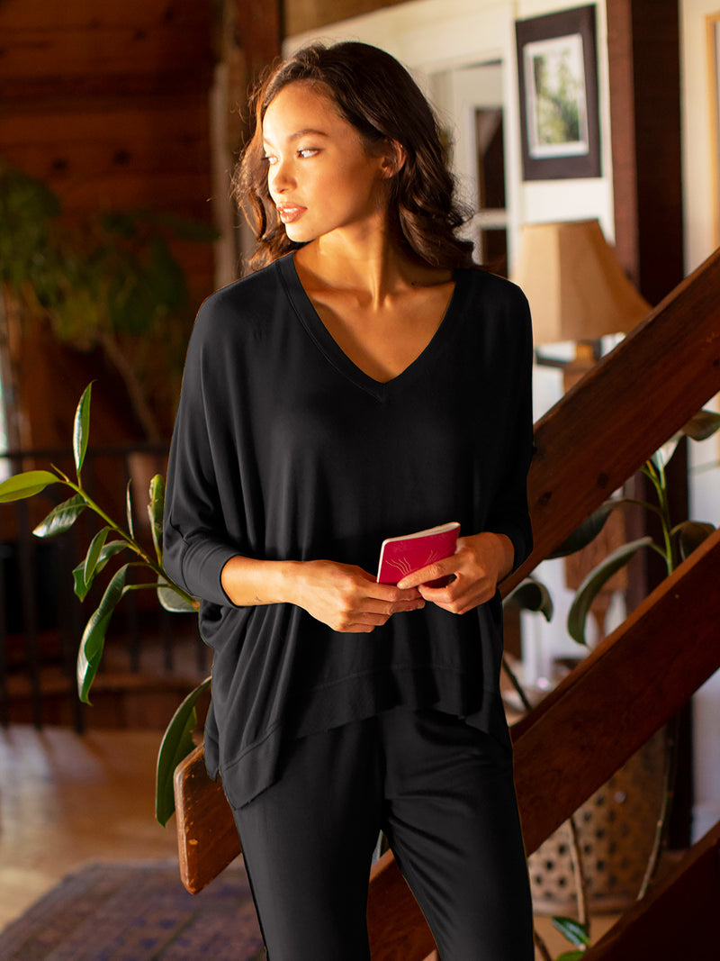 LVHR Sabina V Neck in black. Micro modal french terry domain 3/4 sleeve top with slightly distressed rib cuff and hem and side slits. Styled with the Sabina Pant. Front.