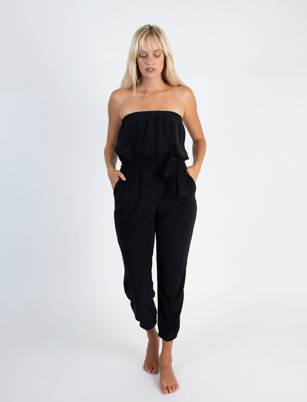 LVHR Camilla Jumpsuit in black made from super soft organic recycled terry cloth knit with front pockets and tie sash belt. Elastic cuffs, waist and neckline. Front.