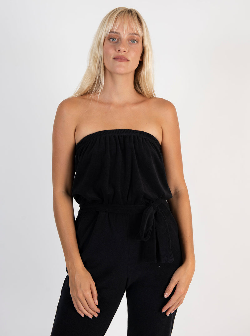 LVHR Camilla Jumpsuit in black made from super soft organic recycled terry cloth knit with front pockets and tie sash belt. Elastic cuffs, waist and neckline. Front, close-up.