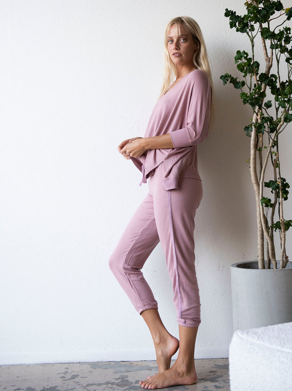LVHR Sabina Crop Pant in vintage rose. Micro modal french terry pant. Slightly cropped length with cotton twill tape side detailing, Adjustable drawstring and elastic waistband. Relaxed fit. Styled with the Sabina Crew. Side view.