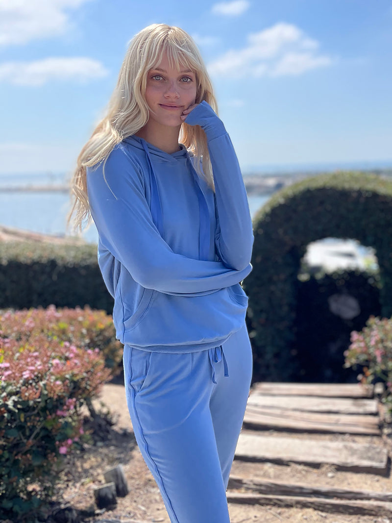 LVHR Sabina Hoodie in indigo. Micro modal french terry sweatshirt with lightly distressed rib cuff and hem and adjustable twill hood cinch. Styled with the Sabina Pant. Front.